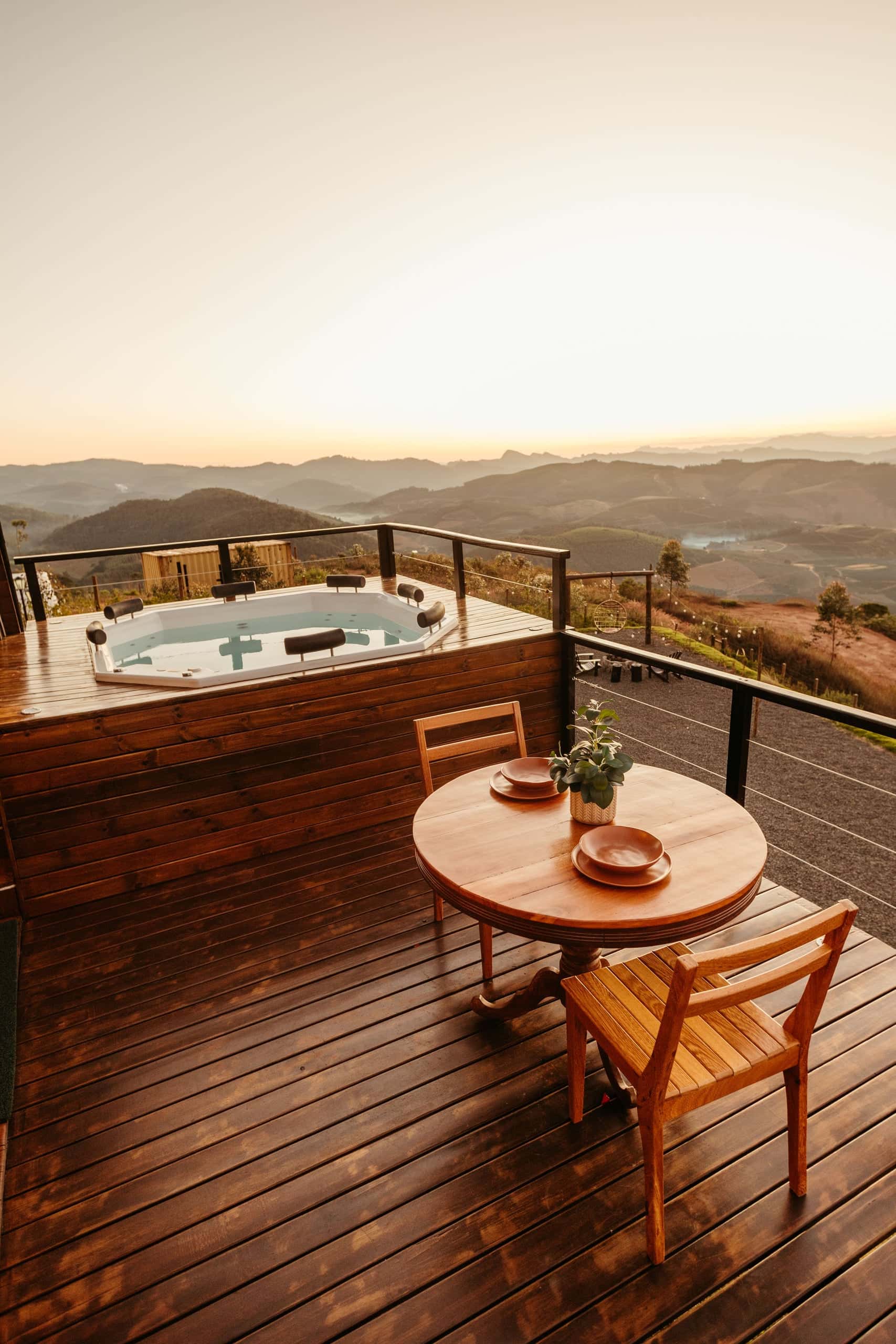 Spa sur une terrasse en bois face aux collines