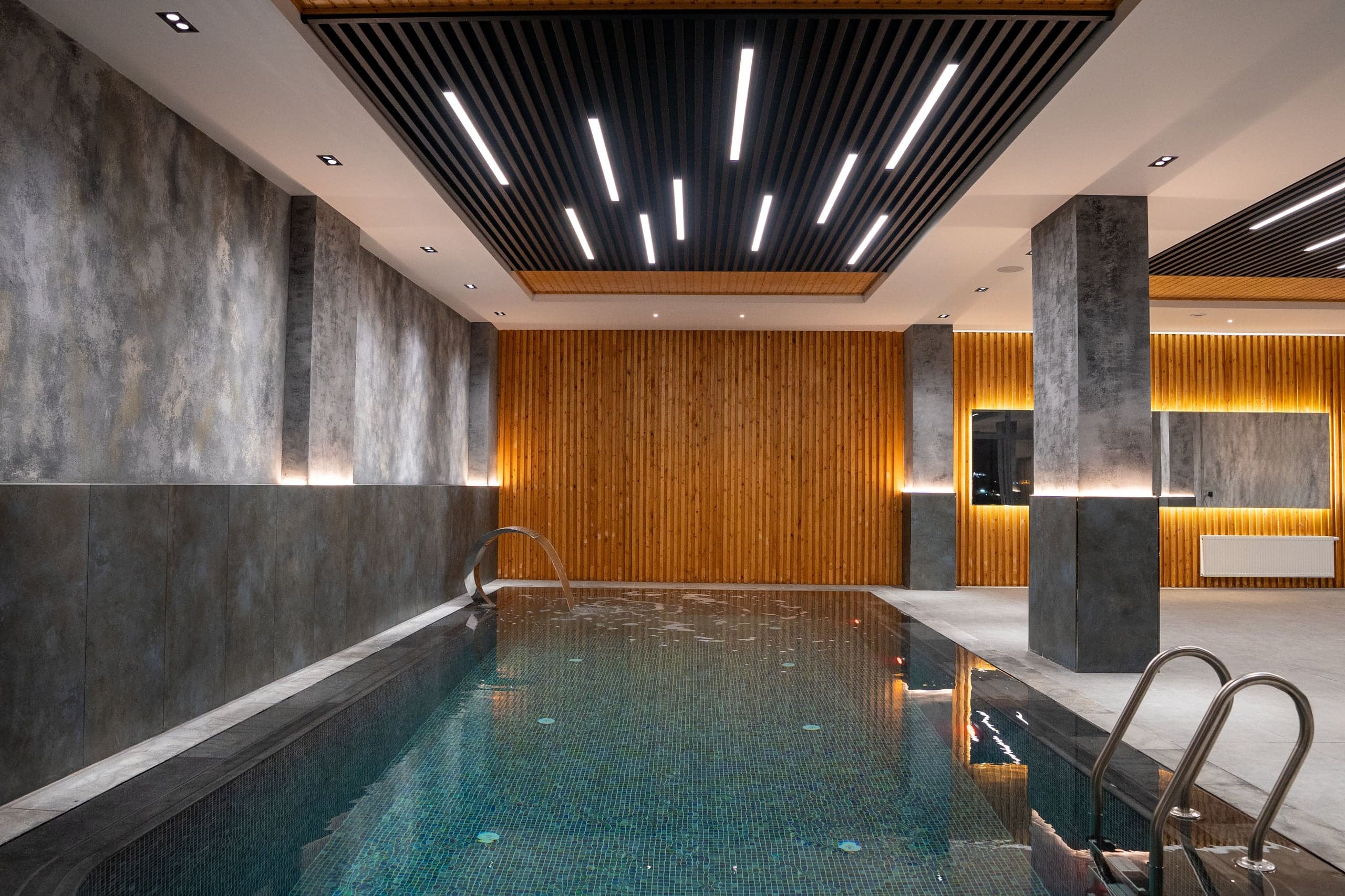 Piscine intérieure, plafond à lames et éclairage