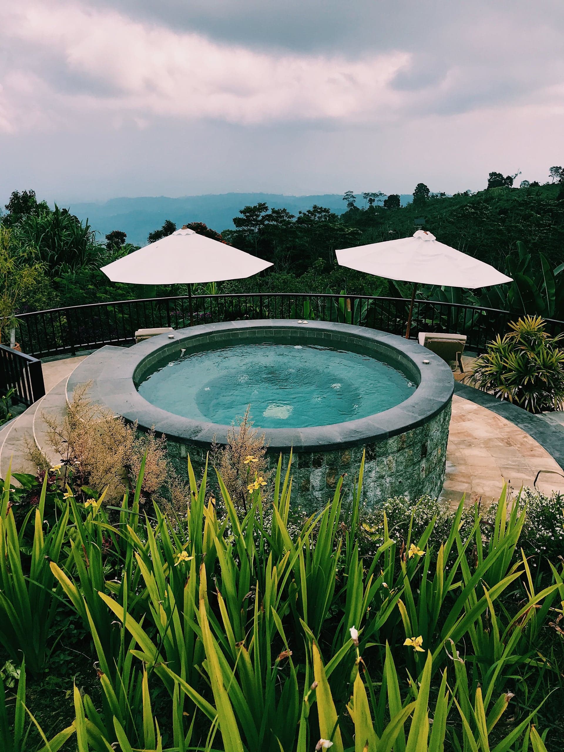Spa rond dans un jardin, sous les parasols