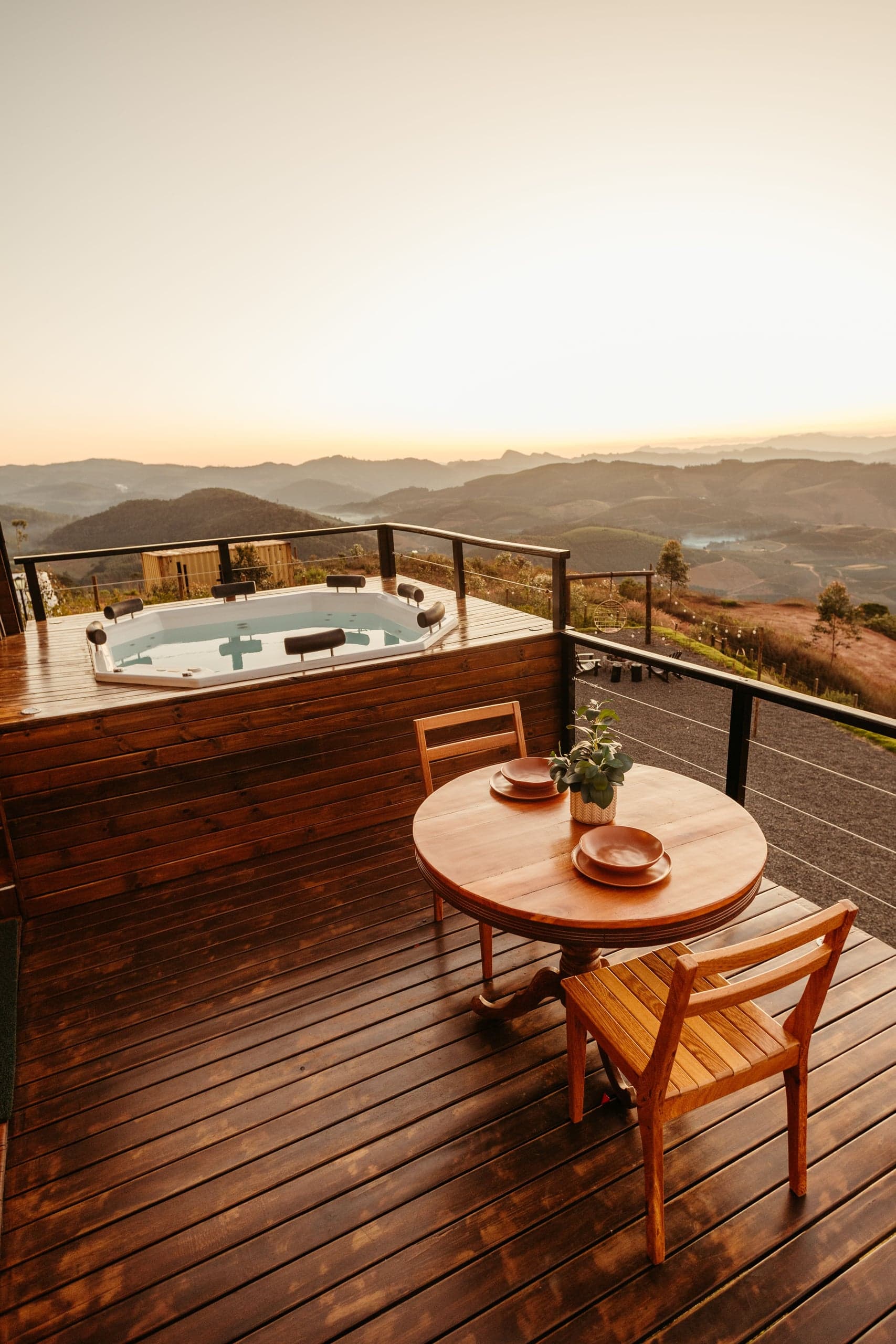 Spa sur une terrasse en bois face aux collines